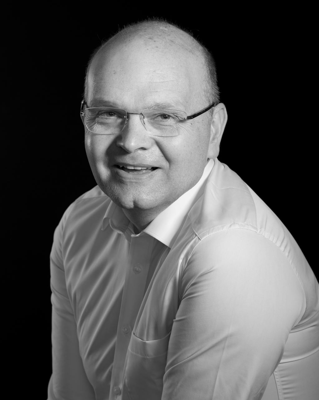 a man wearing glasses posing for the camera