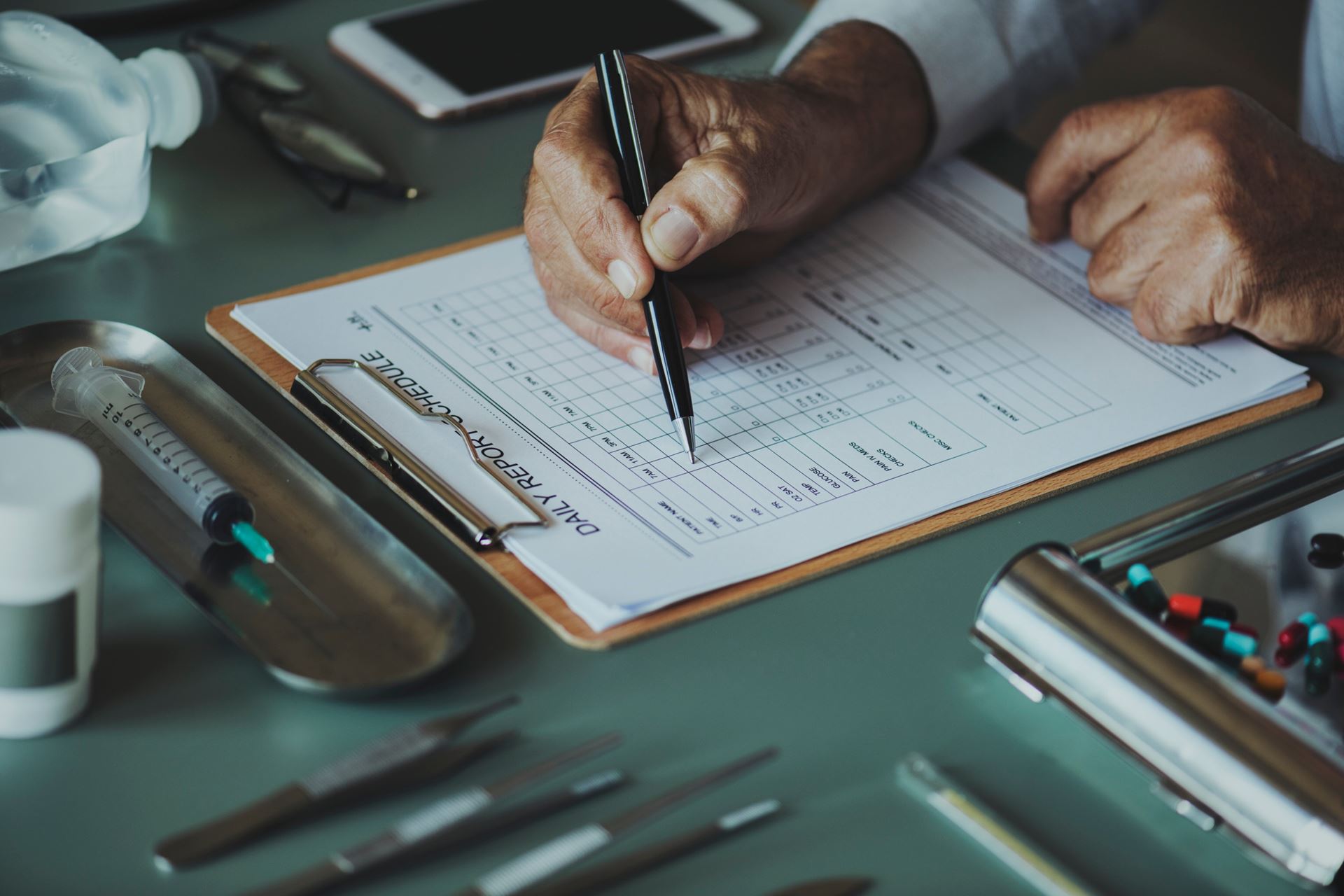 a person sitting at a desk writing something on a clip board